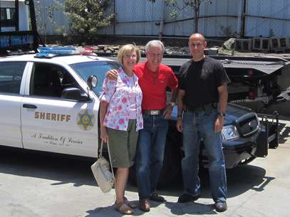 Robert Russell, centro, posa flanquedado por su esposa y por el detective Carlos Ortega tras encontrar su coche Foto: Departamento del Alguacil del condado de Los Angeles / AP