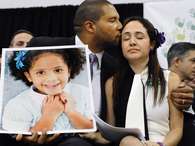 Jimmy Greene, a la izquierda, besa a su esposa Nelba Márquez Greene, mientras él sostiene un retrato de la hija de ambos, Ana, una de las víctimas de la matanaza a tiros en la escuela Sandy Hook, en una conferneica de prensa en Newtown, Connecticut, el lunes 14 de enero de 2013. Foto: AP