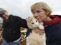 Eric y June Simson muestran a su gato Sammi tras hallarlo entre los escombros Foto: EFE