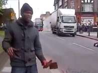 Uno de los autores del crimen, con cuchillos en la mano, explican por qu&eacute; mat&oacute; al supuesto soldado (tendido en la calle) Foto: Captura Video