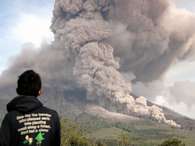 Homem observa erupção do Monte Sinabung a partir de Tiga Pancur, na ilha de Sumatra, Indonésia. O vulcão, de 2,6 mil metros, está em atividade esporádica desde setembro Foto: AP