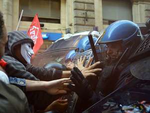 Com escudos e cassetetes, policiais tentam impedir o avanço dos manifestantes Foto: AFP
