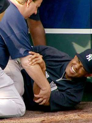 El panameño Mariano Rivera, de los Yanquis de Nueva York, al centro, hace gestos de dolor tras torcerse la rodilla izquierda mientras atrapaba bolas durante una práctica de bateo antes del partido de visita contra los Reales de Kansas City, el jueves 3 de mayo de 2012.  Foto: YES Network / AP