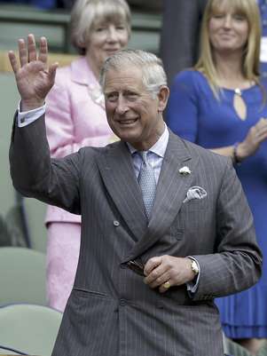 El príncipe Carlos saluda al público al llegar al palco real en Wimbledon para el partido entre Roger Federer y Fabio Fognini el miércoles, 27 de junio de 2012, en Londres. Foto: Kirsty Wigglesworth / AP