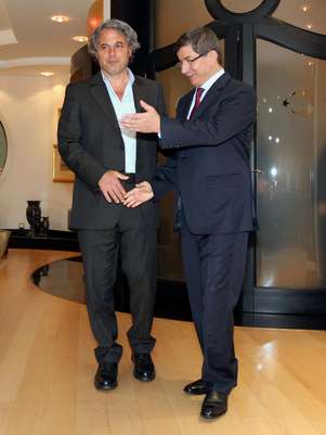 El canciller Ahmet Davutoglu, derecha, y el general Manaf Tlass sonríen a las cámaras antes de una cena de fin de ayudo de ramadán Foto:  Hakan Goktepe / AP