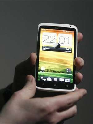 Imagen de archivo de una persona con un teléfono móvil de la firma HTC tras una conferencia de prensa en el Congreso Mundial de Móviles en Barcelona, España, feb 26 2012. El fabricante taiwanés de teléfonos avanzados HTC dijo el viernes que prevé que sus ventas crezcan en China y caigan en otras regiones, pronosticando un descenso de sus ingresos de hasta el 23 por ciento, en una muestra de lo difícil que será su camino hacia la recuperación. Foto: Gustau Nacarino / Reuters en español
