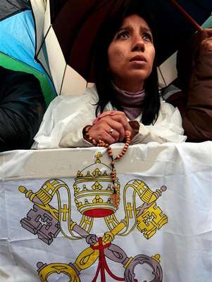 El papa Francisco I se convertirá oficialmente en el nuevo líder de la Iglesia católica el 19 de marzo, dijo el miércoles el Vaticano. En la imagen, una fiel espera a que se alce el humo de la chimenea de la capilla Sixtina durante un segundo día de cónclave para elegir un nuevo Papa, en la plaza de San Pedro, en el Vaticano, el 13 de marzo de 2013. Foto: Eric Gaillard / Reuters