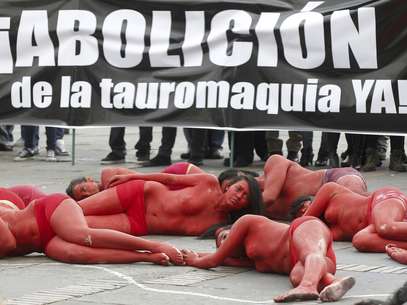 Jóvenes activistas yacen en el suelo con los cuerpos pintados de rojo simulando sangre en una protesta contra las corridas de toros en Bogotá, Colombia, el jueves 9 de febrero de 2012.  Foto: Fernando Vergara / AP