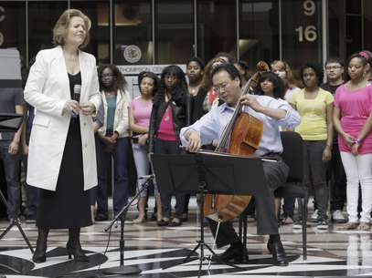 El chelista Yo-Yo Ma y la soprano Renee Fleming, izquierda, se presentan con un coro de estudiantes de secundaria en la rotonda del edificio del Estado de Illinois, el lunes 19 de marzo de 2012 en Chicago. La presentación sirvió para promover la educación artística para jóvenes.  Foto: Kiichiro Sato / AP