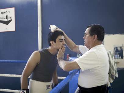 Antonio DeMarco, campeón liviano del CMB, es asistido por el entrenador Rómulo Quirarte durante una sesión de entrenamiento el 21 de febrero del 2012  en el gimnasio Crea, que da esperanzas de una vida digna a decenas de niños en Tijuana, una ciudad azotada por la violencia del narcotráfico.  Foto: Alejandro Cossio / AP