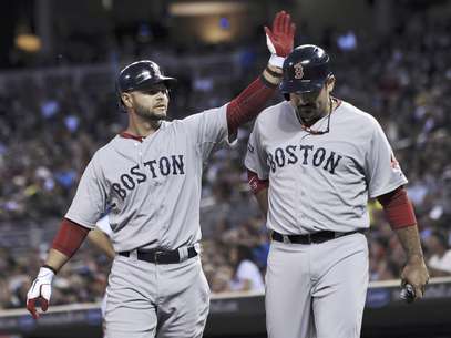 Cody Ross, izquierda, le pega en el caso al mexicano Adrián González, ambos de los Medias Rojas de Boston luego de que anotaron gracias a un sencillo de Jarrod Saltalamacchia en contra de los Mellizos de Minnesota en el tercer episodio del partido del miércoles 25 de abril de 2012, en  Minneapolis.  Foto: Jim Mone / AP