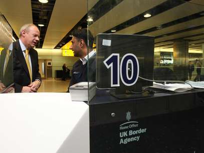 El ministro de Inmigración de Gran Bretaña, Damian Green, habla con un agente de aduanas Shafait Ali durante una visita a la Terminal 3 del Aeropuerto de Heathrow, en Londres, el martes 1 de mayo de 2012.  Foto: Steve Parsons/PA Wire / AP