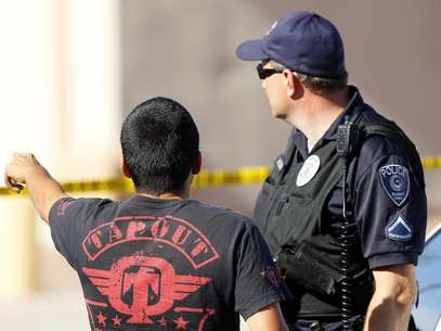 Un hombre señala a un agente de la policía de Gilbert que una hija de él se encuentra en el interior de la vivienda donde cinco personas fueron muertas el miércoles 2 de mayo de 2012 en Gilbert, Arizona.  Foto: Matt York / AP