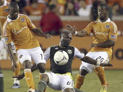 El mediocampista Franck Songo'o de los Timbers de Portland cae ante el marcaje de Corey Ashe del Dynamo, derecha, en la primera mitad del partido de la MLS que terminó 0-0 en Houston el martes 15 de mayo de 2012.  Foto: Houston Chronicle, Nick de la Torre)  MANDATORY CREDI / AP