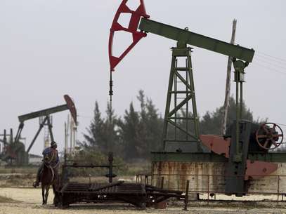 En esta imagen del 12 de enero de 2012, Alfonso Arias monta su caballo cerca de una bomba de extracción de petróleo operada por la compañía propiedad del gobierno Cuba Petróleos, Cupet, en Santa Cruz del Norte, Cuba.  Foto: Franklin Reyes, Archivo / AP