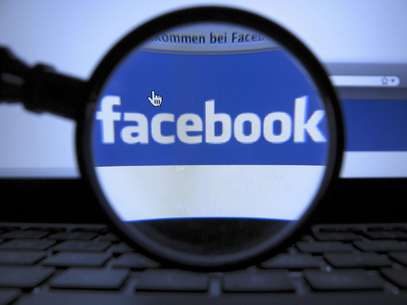 FILE - In this Oct. 10, 2011 file photo, a magnifying glass is posed over a monitor displaying a Facebook page in Munich. Facebook is letting its nearly 1 billion users vote on changes to its privacy policy beginning on Friday, June 1, 2012. This is the second time Facebook let users vote on policy changes. The first time was in 2009 when Facebook was a much smaller, privately held company with about 200 million users  Foto: dapd, Joerg Koch / AP