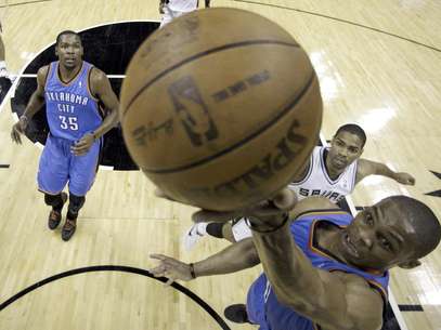 Russell Westbrook, del Thunder de Oklahoma City, encesta ante la mirada de su compañero Kevin Durant (35) y el jugador de los Spurs de San Antonio Gary Neal (14) durante la primera mitad del Juego 5 de la serie por el campeonato de la Conferencia del Oeste de la NBA el lunes 4 de junio de 2012, en San Antonio. El Thunder venció 108-103 a los Spurs para tomar una ventaja de 3-2 en la serie.  Foto: Eric Gay / AP