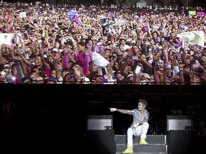 Sentado bajo una pantalla que muestra a la gente en el público, Justin Bieber ofrece un concierto gratuito en el Zócalo de la Ciudad de México, el lunes 11 de junio del 2012.  Foto: Alexandre Meneghini / AP