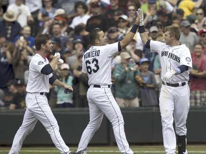 John Jaso, izquierda, y el venezolano Jesús Montero, centro, de los Marineros de Seattle, felicitan a Justin Smoak tras batear el sencillo que decidió la victoria sobre los Gigantes de San Francisco, en la parte baja de la novena entrada del juego del domingo 17 de junio de 2012, en Seattle.  Foto: Stephen Brashear / AP