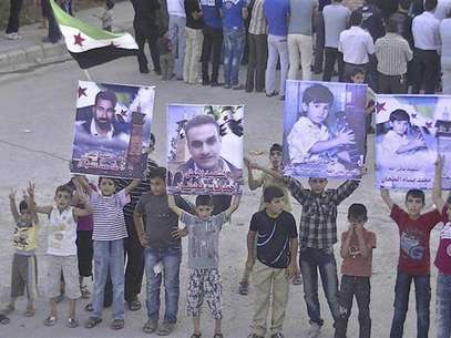 Boys hold posters of people whom protesters say were killed by forces loyal to Syria's President Bashar al-Assad, during a demonstration in Deraa June 17, 2012. Picture taken June 17, 2012. Foto: Handout / Reuters In English