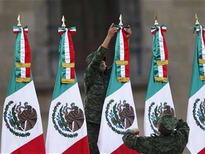 Imagen de archivo de un soldado arreglando una serie de banderas durante las celebraciones del Día de la Bandera en la plaza el Zócalo en Ciudad de México, feb 24 2012. El Congreso de México podría ser otra vez centro de tortuosas negociaciones, lo que demoraría reformas clave para el país, por una mayor presencia de la izquierda y posiciones encontradas en temas controvertidos en el PRI, la fuerza favorita para ganar las elecciones presidenciales. Foto: Tomas Bravo / Reuters en español