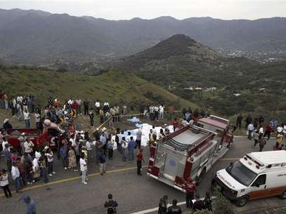Bodies, covered by white sheets, lie on the road next to the site of a passenger bus crash in the southwestern state of Guerrero June 24, 2012. At least 32 people were killed on Sunday after the bus they were travelling in turned over on the wet road, a Red Cross official said. At least seven people were injured and believed to be in serious condition, the official said. The official said most of the people inside the passenger bus were wearing T-shirts emblazoned with the logo of Mexico's Labor Party (PT) Foto: Margarito Perez Retana / Reuters In English