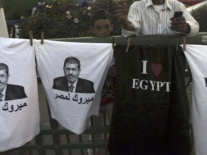 A boy stands near t-shirts with images of elected president Mohamed Mursi and words that read "Congratulations to Egypt" that are sold during a sit-in against the military council and the decision to dissolve parliament, at Tahrir Square in Cairo June 28, 2012. Foto: Amr Abdallah Dalsh / Reuters In English