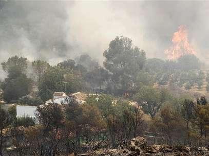 Dos graves incendios declarados en la provincia de Valencia continuaban el domingo sin control, mientras los trabajos de extinción se centraban en proteger las poblaciones cercanas a los focos, informaron las autoridades. En la imagen, un incendio forestal en Montroi, cerca de Valencia, el 30 de junio de 2012. Foto: Heino Kalis / Reuters