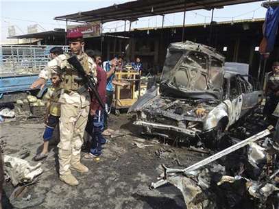 An Iraqi soldier and people inspect the site of a bomb attack in Kerbala July 3, 2012. Foto: Mushtaq Muhammed / Reuters In English