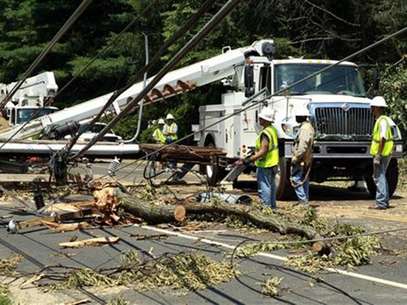 Utility workers try to free up power lines after a huge tree fell across major road in Falls Church, Virginia July 2, 2012. Foto: Kevin Lamarque / Reuters In English