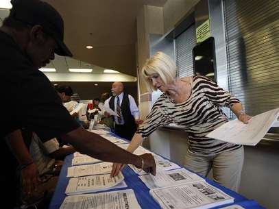 Carlene Gepner of WorkSource hands out job applications at the 11th annual Skid Row Career Fair the Los Angeles Mission in Los Angeles, California, May 31, 2012. Foto: David McNew / Reuters In English