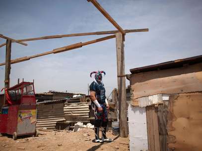 En esta foto del 13 de mayo de 2012, el luchador Crazy Clown va al sanitario antes de participar en el espectáculo itinerante de la Caravana Súper Tarín en las afueras de la capital mexicana. La caravana lleva espectáculos gratuitos de lucha libre a barrios pobres, orfelinatos y cárceles para gente que no puede costearse una entrada de 300 pesos (22 dólares) a un espectáculo profesional en una de las grandes arenas de la capital mexicana.  Foto: Alexandre Meneghini) / AP