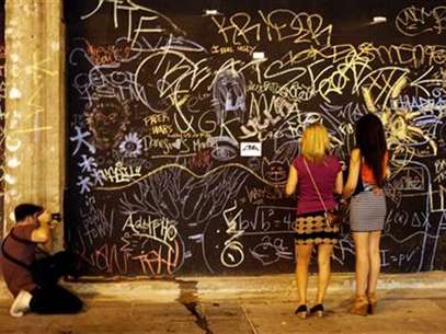 Two women look at chalk graffiti during art walk in Downtown Los Angeles, California July 12, 2012. Foto: Sam Mircovich / Reuters In English