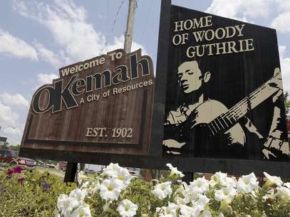 Un letrero recibe a los visitantes de Okemah, Oklahoma, la ciudad natal de Woody Guthrie, el viernes 13 de julio de 2012. Okemah está celebrando el centenario del nacimiento de Guthrie.  Foto: Sue Ogrocki / AP