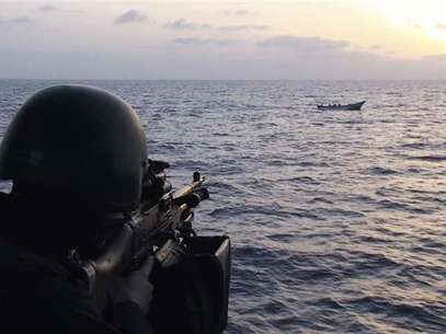 A soldier aboard the Swedish corvette HMS Malmo aims his machinegun at a boat carrying suspected pirates in the Gulf of Aden May 26 2009. Foto: Scanpix / Reuters In English