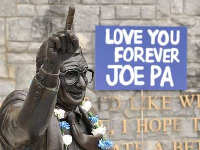 Signs and flowers are seen at the statue of the late Penn State football coach Joe Paterno, before the annual Spring football scrimmage in State College, Pennsylvania April 21, 2012. Foto: Pat Little / Reuters