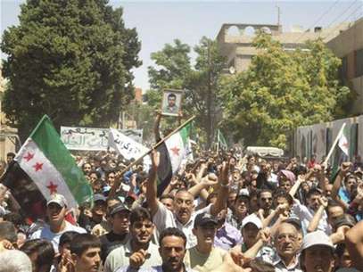 Un grupo de residentes locales participa del funeral de personas que aparentemente fallecieron durante un encuentro con fuerzas del Gobierno sirio en Yabroud, cerca de Damasco, jul 18 2012. Las cámaras muestran una bandera rebelde desplegada en medio de una calle de Damasco regada de escombros. En otra zona de la capital siria, los soldados del Gobierno se refugian detrás de una pared mientras cruzan fuego con los insurgentes. Foto: Handout Imagen para uso no comercial, ni ventas, ni archivos. Solo para uso editorial. No para su venta en marketing o campañas / Reuters en español