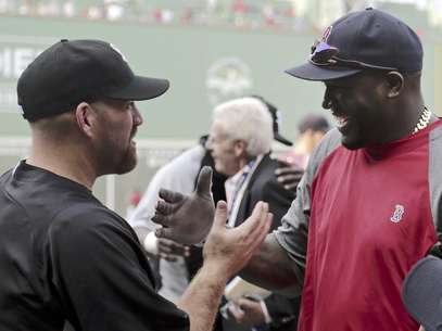 El tercera base de los Medias Blancas de Chicago Kevin Youkilis, izquierda, saluda a su ex compañero de equipo David Ortiz, bateador designado de los Medias Rojas de Boston, durante la práctica de bateo previa a su juego en el Fenway Park, el lunes 16 de juliuo de 2012, en Boston.  Foto: Charles Krupa / AP