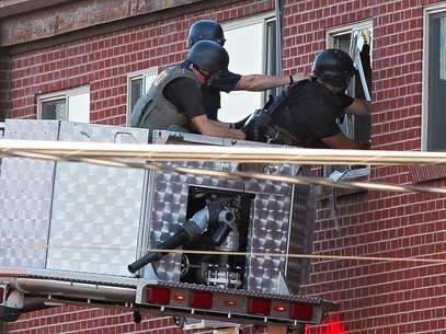 La policía utiliza una cámara de video para ver al interior del apartamento donde vivía el sospechoso.  Foto: Ed Andrieski / AP