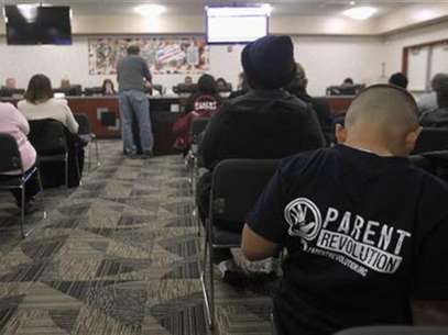 Eight-year-old Abraham Zamarripa sits in the audience in support of Patrick DeTemple, director of NGO Parent Revolution, who is speaking during a Adelanto School District board meeting regarding the parent trigger law, in Adelanto, California March 6, 2012. Foto: Alex Gallardo / Reuters In English