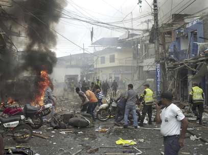 En esta foto del 1 de febrero de 2010, vecinos y policías acuden al lugar donde acababa de explotar una bomba en Tumaco, Colombia, sobre la costa del Pacífico, en un atentado atribuido a las FARC que dejó 5 muertos y decenas de heridos.  Foto: /Victor Manuel Correa, Diario del Sur, File / AP