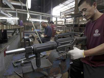 A former illegal gunsmith inspects a newly assembled multi-action shotgun at Shooters Arms, a gun manufacturing company exporting different kinds of weapons to other countries, in Cebu city in central Philippines July 7, 2012. Foto: Erik De Castro / Reuters In English