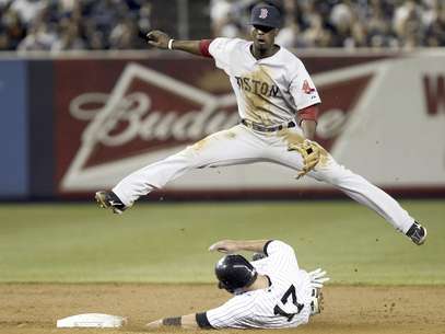 El dominicano Pedro Ciriaco, de los Medias Rojas de Boston, salta sobre Jayson Nix, de los Yanquis de Nueva York, en el partido del domingo 29 de julio de 2012.  Foto: Seth Wenig / AP