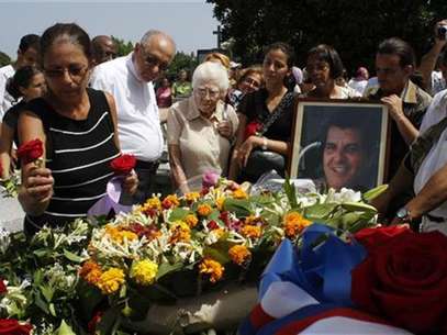 Ofelia Acevedo, wife of Oswaldo Paya, (L), one of Cuba's best-known dissidents, places a rose on the tomb of her husband during his burial in Havana July 24, 2012. Foto: Stringer / Reuters In English