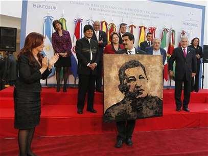 Argentina's President Cristina Fernandez de Kirchner (front L) applauds after giving Venezuela's Foreign Minister Nicolas Maduro a portrait of President Hugo Chavez painted by Argentine artist Norberto Filippo as a souvenir during the annual summit of the Mercosur trade bloc in Mendoza, June 29, 2012. Foto: Enrique Marcarian / Reuters In English