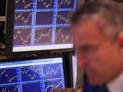 Price charts are displayed on a screen behind a trader as he works on the floor of the New York Stock Exchange after the closing bell in New York November 11, 2011. Foto: Lucas Jackson / Reuters In English