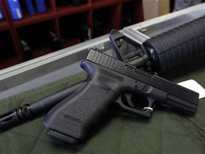 A Glock 22 pistol is seen laying on a Palmetto M4 assault rifle at the Rocky Mountain Guns and Ammo store in Parker, Colorado July 24, 2012. Foto: Shannon Stapleton / Reuters In English