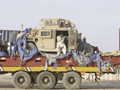 Dos vehículos militares aparecen el viernes 6 de julio de 2012 sobre la plataforma de un camión en una terminal en la localidad paquistaní de Chaman en la frontera con Afganistán. Pakistán aceptó a principios de julio reabrir su territorio al paso de las caravanas de la OTAN con provisiones para sus fuerzas en Afganistán. La medida fue festejada, también, por el Talibán debido al dinero que recibe de empresas de seguridad, dijeron comandantes del grupo el martes 31.  Foto: Matiullah Achakzai / AP