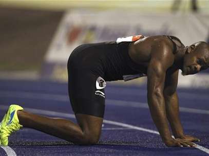 Asafa Powell kneels on the track after their men's 100 meters final event at the Jamaican Olympic trials in Kingston city, June 29, 2012. Foto: Ivan Alvarado / Reuters In English