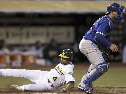 Coco Crisp, izquierda, de los Atléticos de Oakland se desliza para anotar detrás del receptor de los Azulejos de Toronto Jeff Mathis en la quinta entrada el viernes por la noche 3 de agosto del 2012, en Oakland, California. Crisp anotó con fly de sacrificio de Josh Reddick, de Oakland.  Foto: Ben Margot / AP